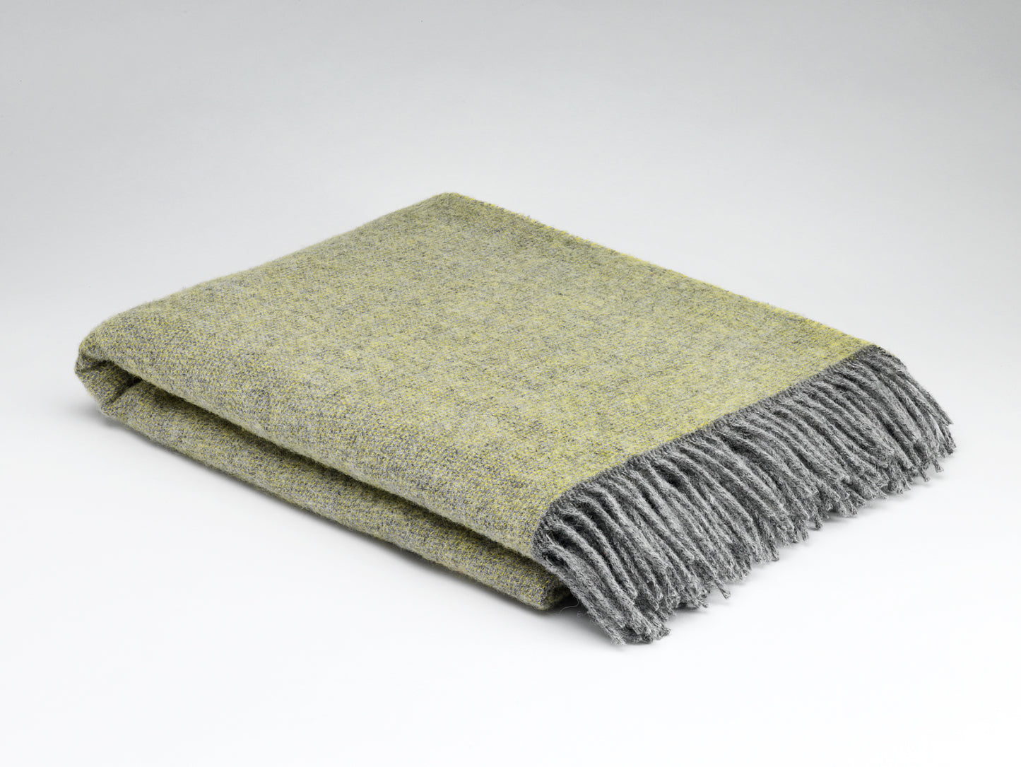 Folded green and gray blanket on a white background