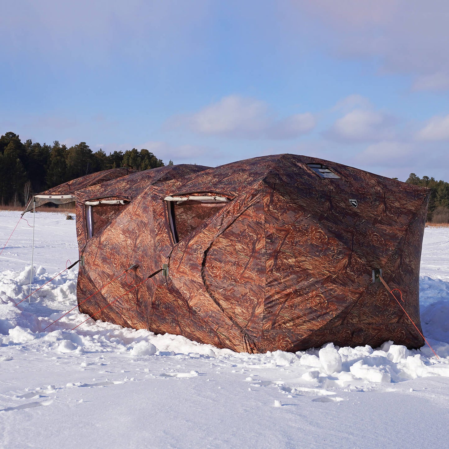 Bereg hot tent cube in a snowy field with trees in the background